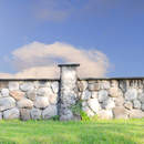 Фотообои с каменным забором и зеленой травой на фоне голубого неба